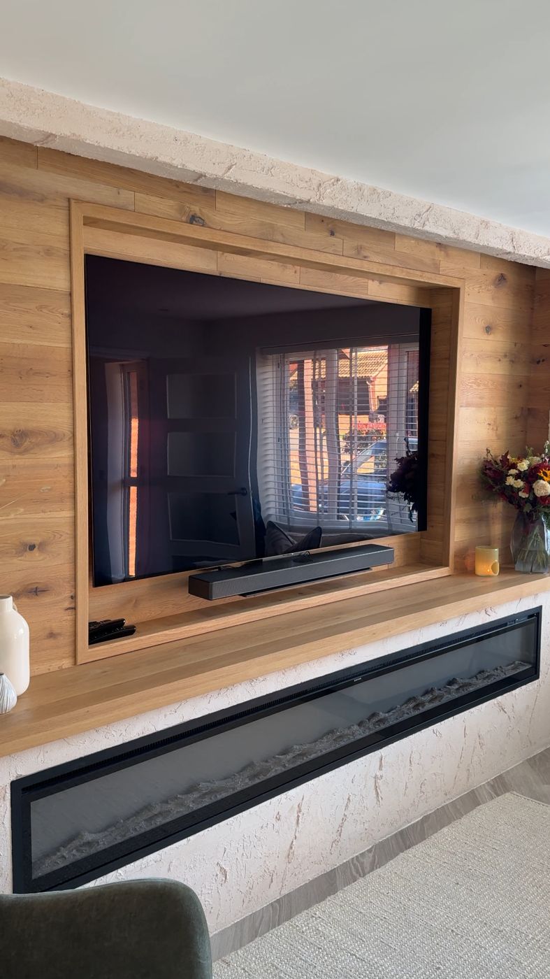 Oak-panelled media wall with textured plaster and inset fire
