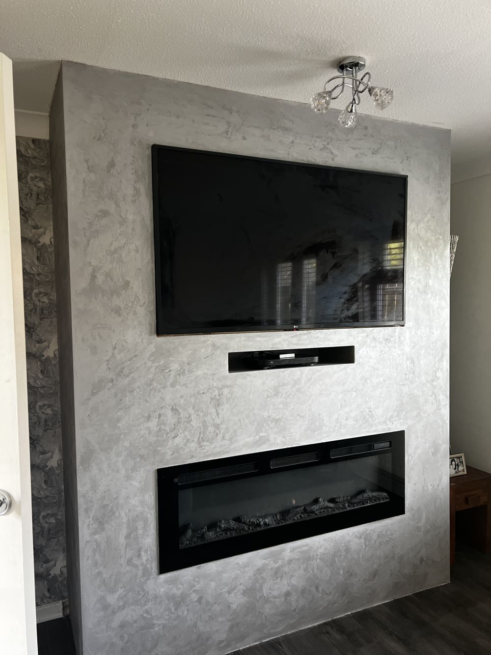 Silver Venetian plaster media wall with inset fire