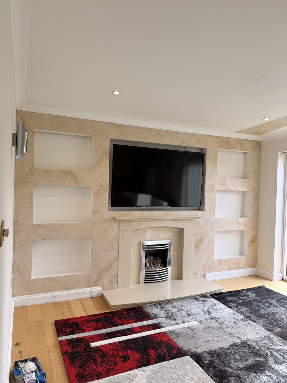 Cream marble-effect media wall with six display niches